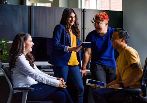 A diverse group of coworkers engaging in a lively discussion in a stylish office environment.